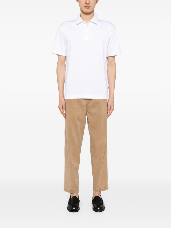 Full look on model of the BOSS Logo Patch Cotton Polo Shirt in White, styled with chinos for a sharp, casual outfit.