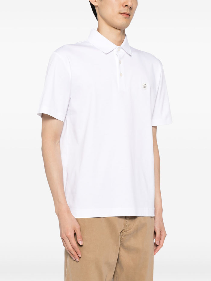 Side angle on model of the BOSS Logo Patch Cotton Polo Shirt in White, highlighting the tailored fit and smooth cotton material.