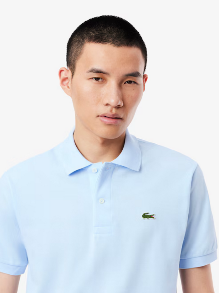 Close-up detail of LACOSTE Light Blue polo shirt showing piqué cotton texture and quality construction