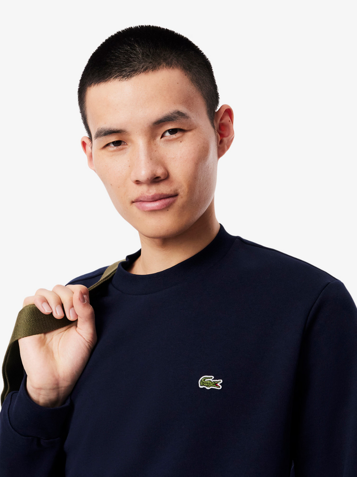 Close-up detail of LACOSTE fleece sweatshirt showing fabric texture and quality construction in Midnight Blue