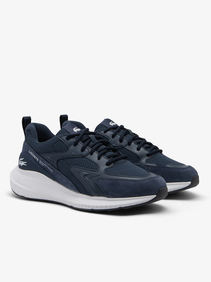 Close-up of LACOSTE L003 Evo sneaker heel in navy blue with LACOSTE text branding and contrast white midsole