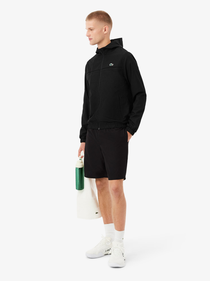 Back view of LACOSTE black taffeta sport shorts showing embroidered crocodile on left leg and elasticated waistband