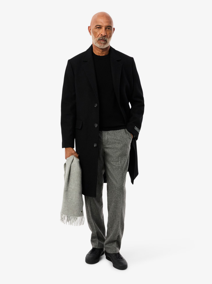 LACOSTE black monochrome sweater side profile highlighting crew neck collar and relaxed fit silhouette