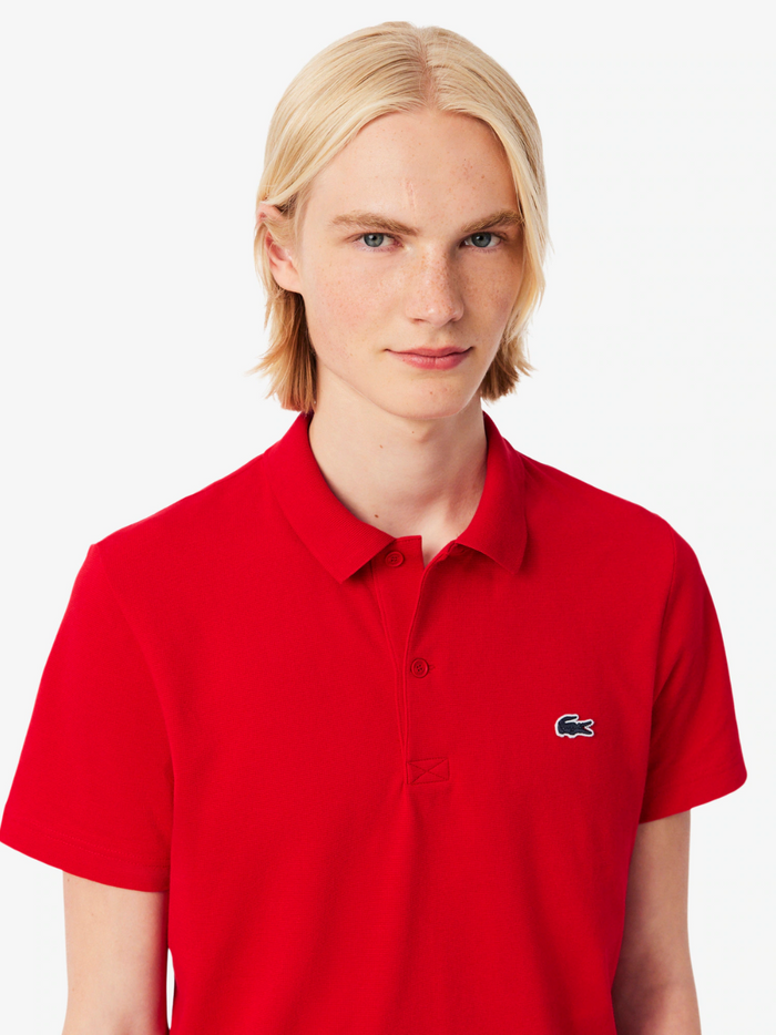 LACOSTE regular fit cotton blend polo shirt in red - detail view of the signature crocodile emblem and collar construction