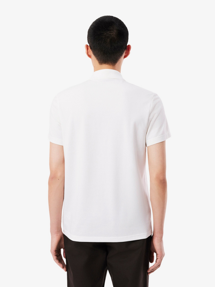 LACOSTE Polo Shirt - Detail shot of signature crocodile logo embroidered on white cotton polyester blend fabric