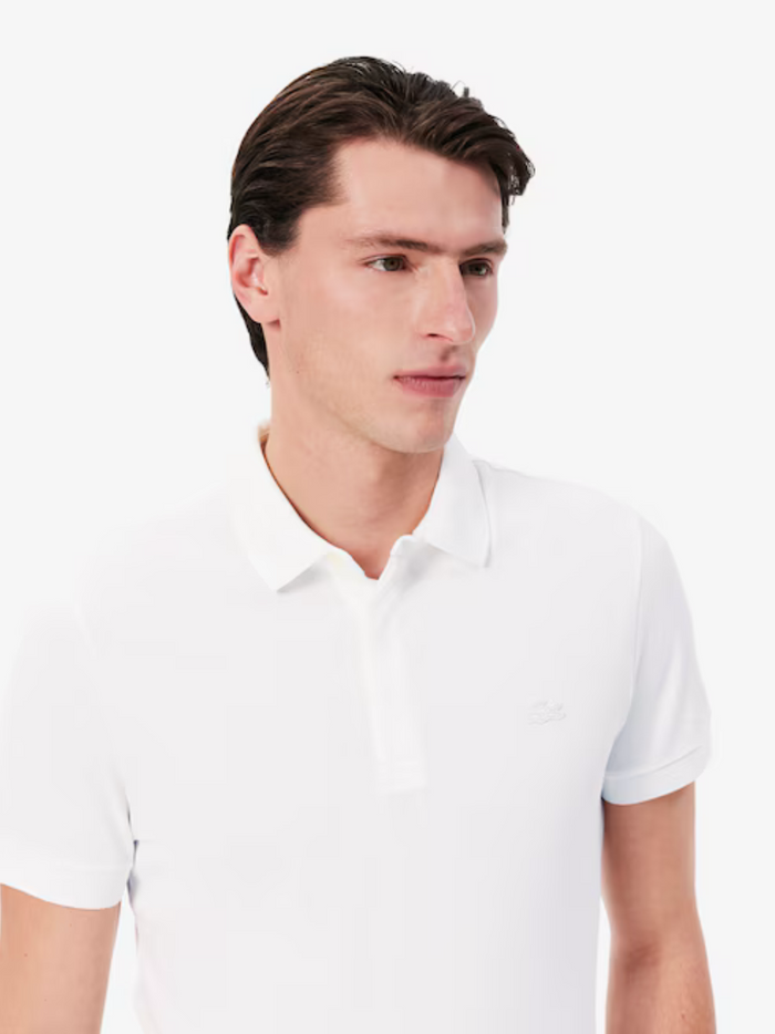 LACOSTE Regular Fit Paris Stretch Piqué Polo Shirt White - close-up detail of embroidered crocodile logo and stretch piqué texture