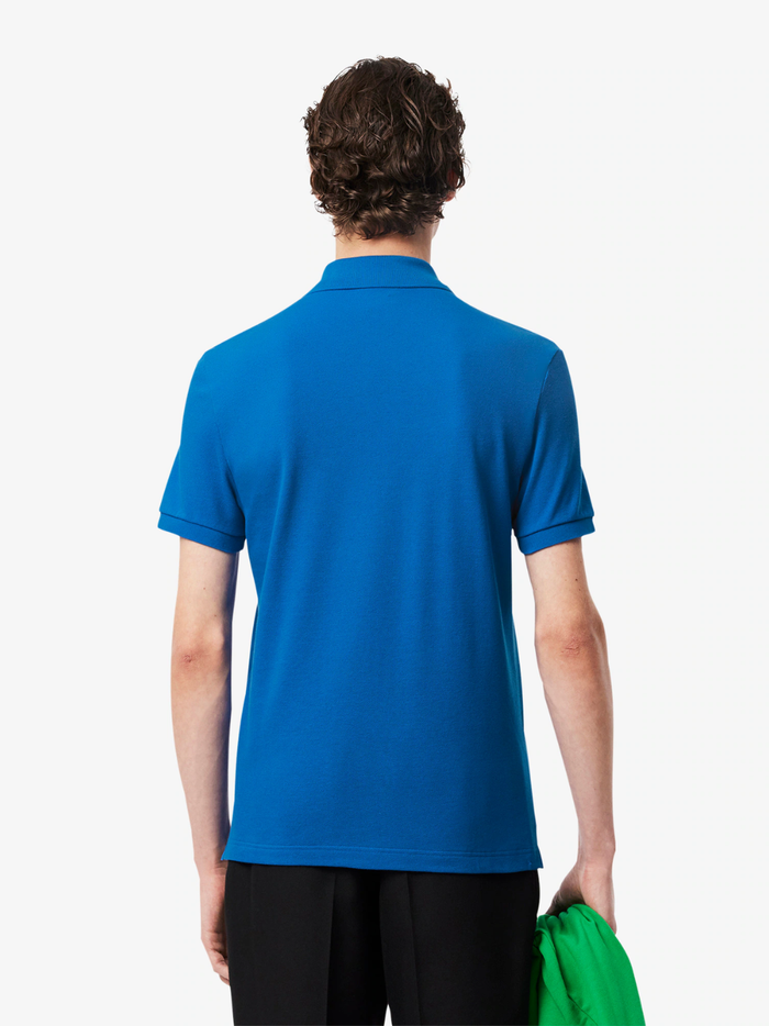 Close-up of LACOSTE polo shirt ribbed collar, mother-of-pearl buttons, and premium piqué fabric weave in denim blue
