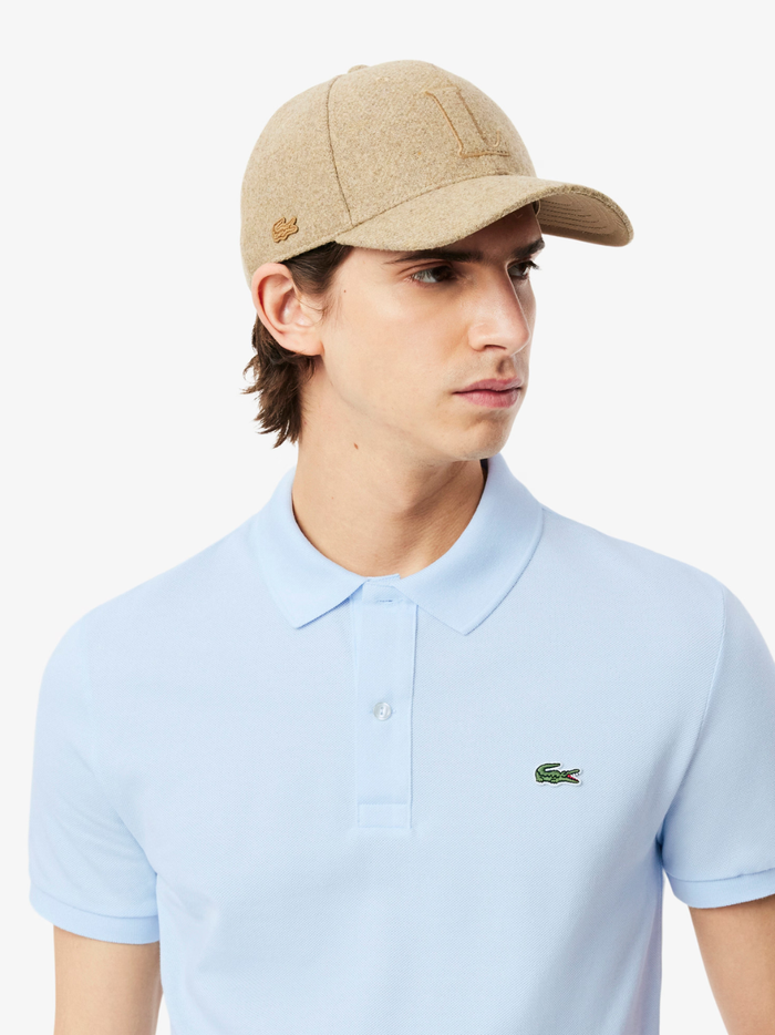 Side profile of LACOSTE L.12.12 light blue polo shirt highlighting slim fit cut and ribbed collar detail