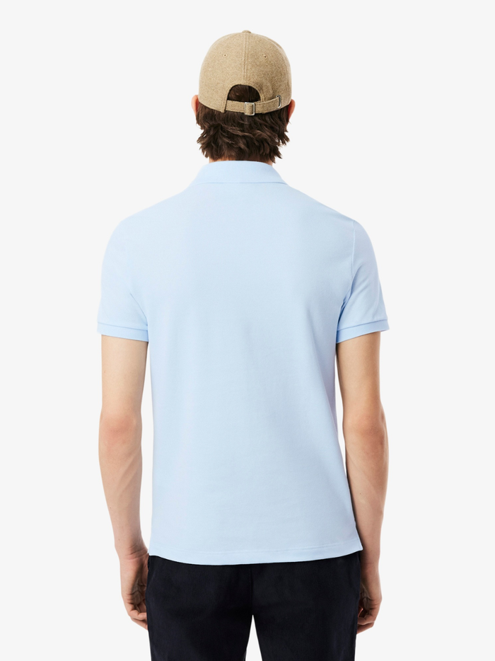 Close-up of LACOSTE polo shirt ribbed collar, mother-of-pearl buttons, and premium piqué fabric weave in light blue