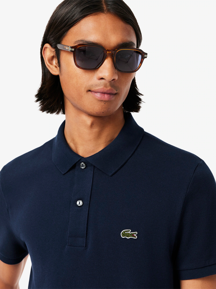 Side profile of LACOSTE L.12.12 midnight blue polo shirt highlighting slim fit cut and ribbed collar detail