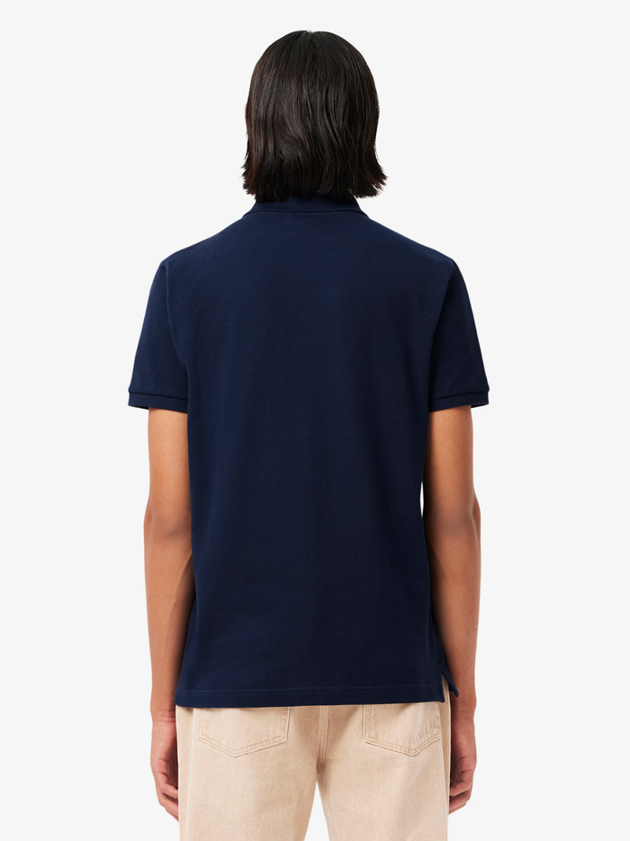 Close-up of LACOSTE polo shirt ribbed collar, mother-of-pearl buttons, and premium piqué fabric weave in midnight blue