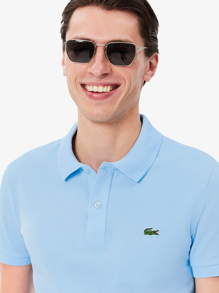 Side profile of LACOSTE L.12.12 pale blue polo shirt highlighting slim fit cut and ribbed collar detail