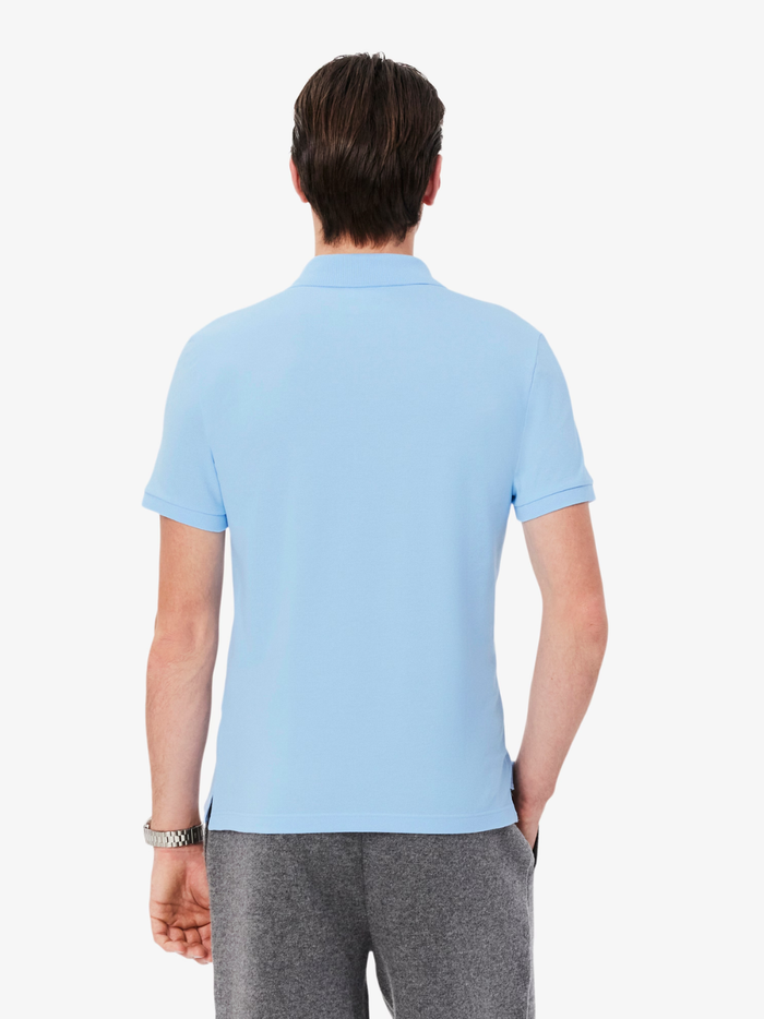 Close-up of LACOSTE polo shirt ribbed collar, mother-of-pearl buttons, and premium piqué fabric weave in pale blue