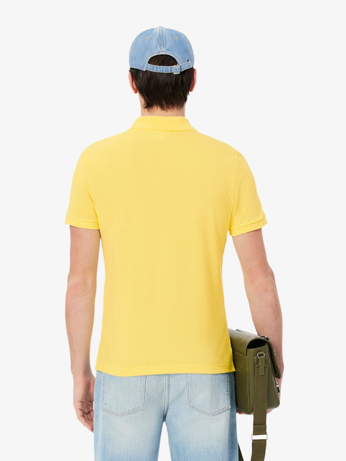 Close-up of LACOSTE polo shirt ribbed collar, mother-of-pearl buttons, and premium piqué fabric weave in pastel yellow