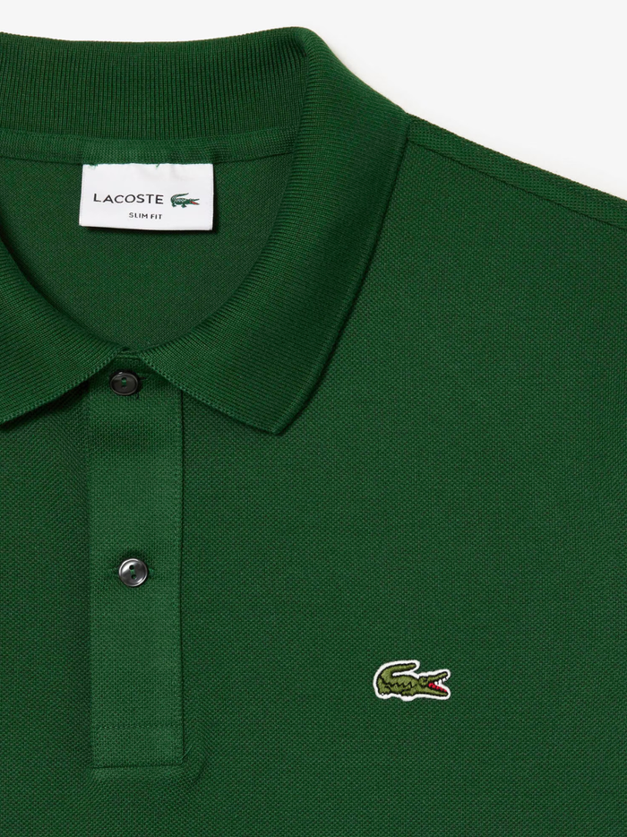 Detail shot of iconic LACOSTE green crocodile embroidery on pine green L.12.12 piqué polo shirt chest