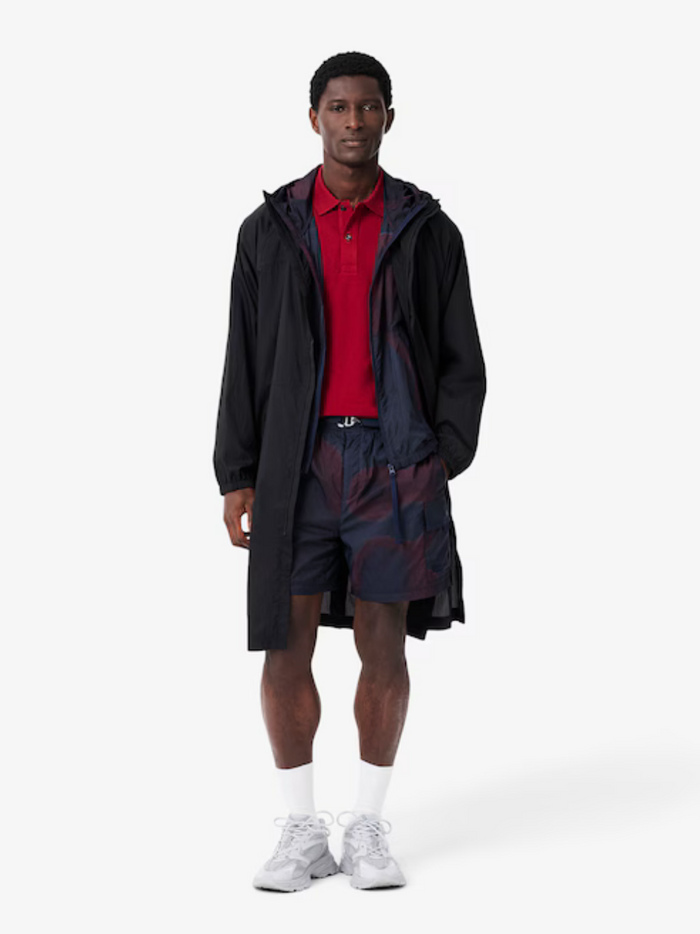 LACOSTE Slim Fit L.12.12 Piqué Polo Shirt Red - side profile view highlighting the tailored slim fit silhouette