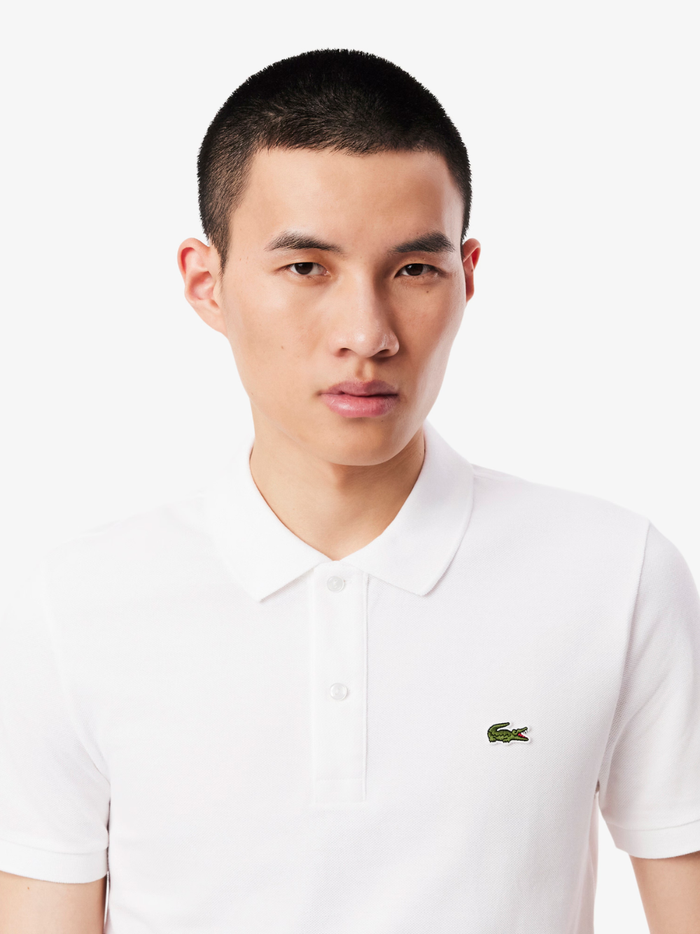 Side profile of LACOSTE L.12.12 white polo shirt highlighting slim fit cut and ribbed collar detail