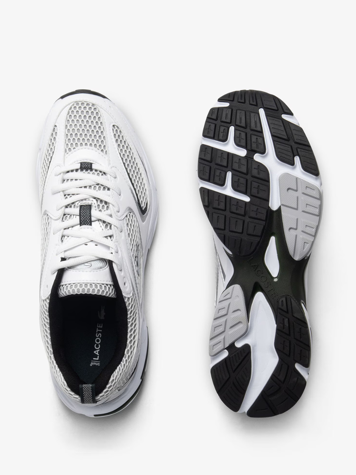 Outsole view of LACOSTE Storm 96 2K sneakers displaying white and grey rubber sole with multi-directional tread pattern and LACOSTE branding