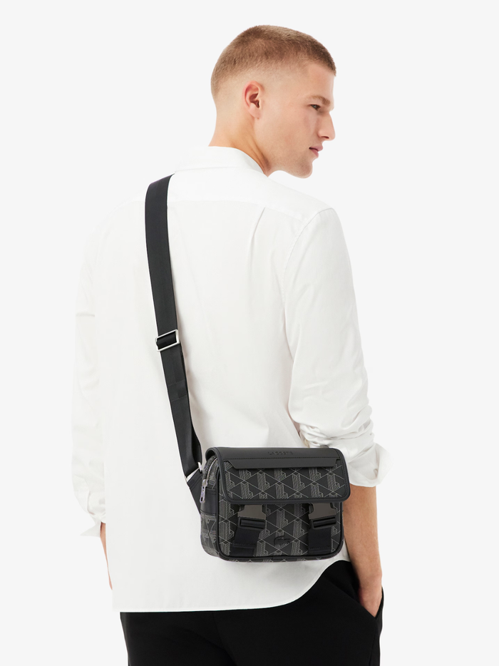 Side view of LACOSTE The Blend satchel displaying structured silhouette and canvas monogram pattern