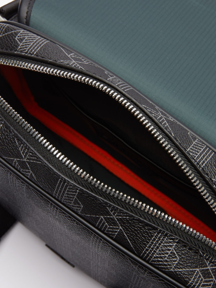 Detail of LACOSTE satchel bag showing monogram print, metal clip hardware, and adjustable shoulder strap