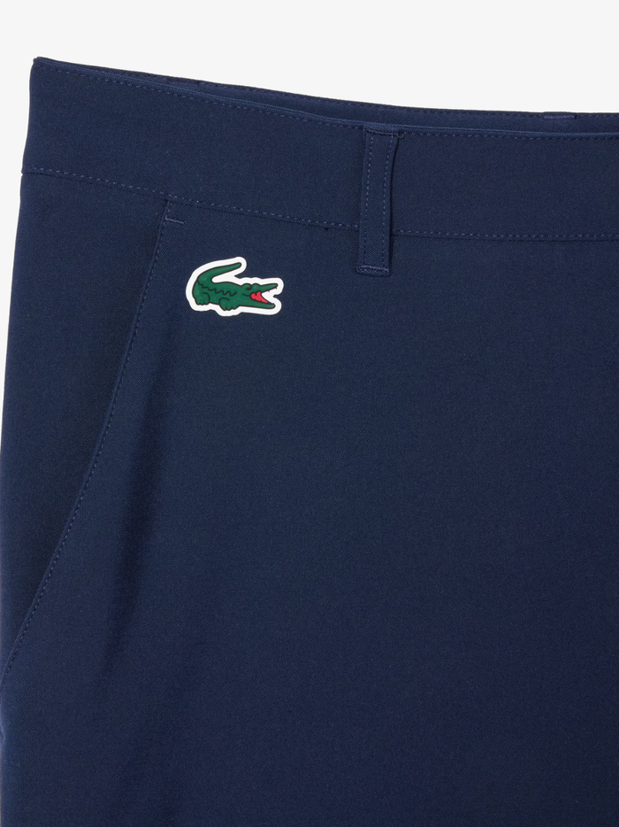 LACOSTE Ultra Dry Golf Shorts in midnight blue, full product view showing Bermuda length and technical stretch fabric