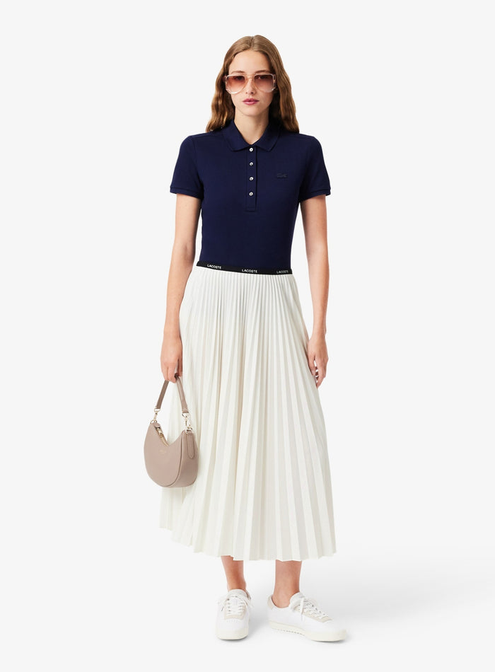 White Lacoste pleated midi skirt showing elegant drape and movement - side profile