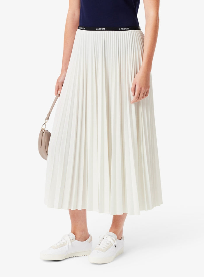 Close-up of Lacoste skirt pleating detail and premium fabric texture in white